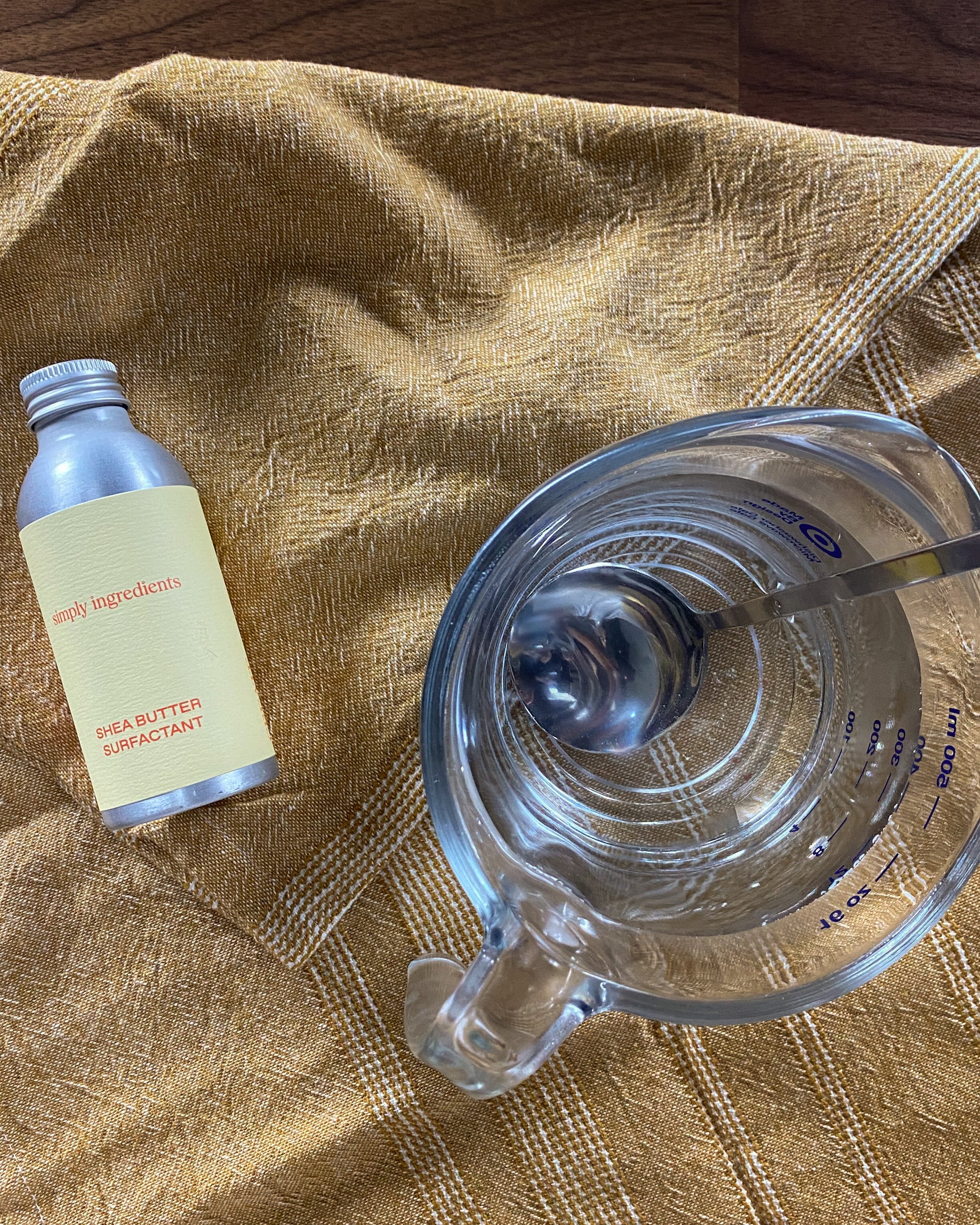 Shea Butter Surfactant next to bowl of the micellar water recipe with spoon